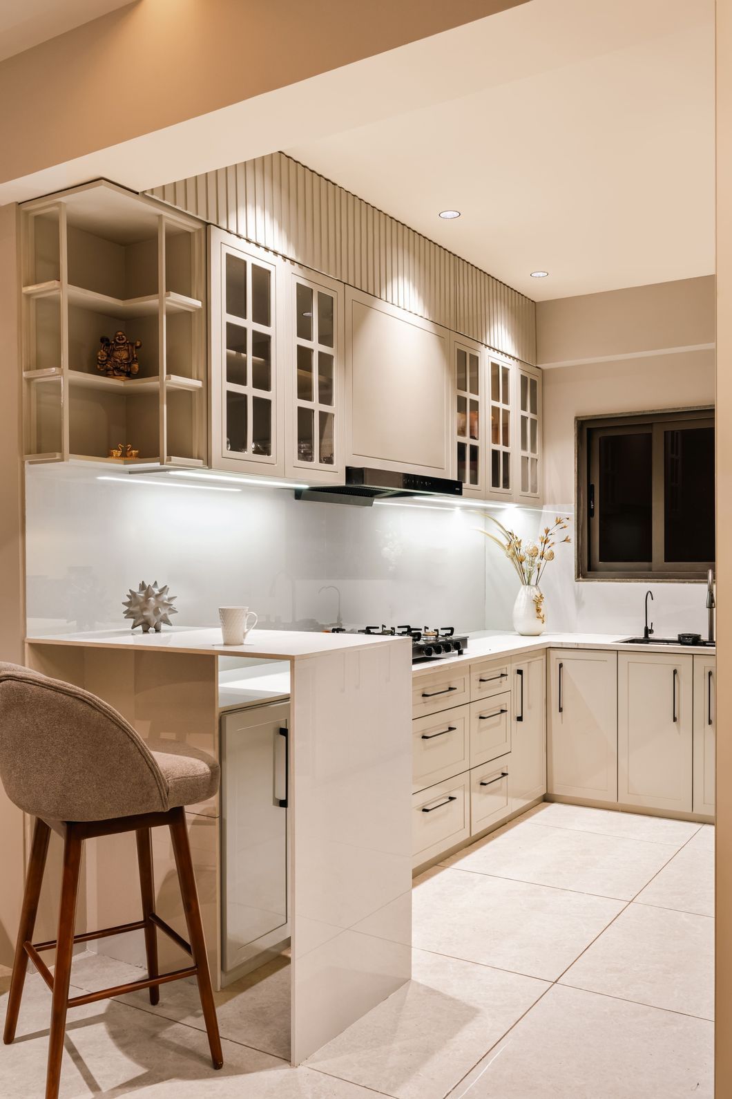 Warm kitchen interior with marble countertops and cream cabinetry